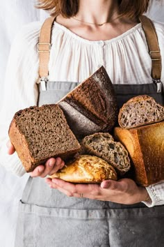 a woman holding bread and loaves in her hands