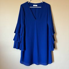 This Stunning Bailey 44 Baroness Shift Dress In Royal Blue Is Perfect For Any Occasion. The Dress Features A V-Neckline, Zip Closure, And Long Bell Sleeves With Ruffle Accents. The Dress Is Suitable For Weddings, Work, Parties, Or Casual Wear. It Comes In Size Large And Has A Classic Fit. The Dress Is Made Of Polyester And Is Dry Clean Only. It Is Perfect For Summer, Fall, Or Spring. Message Me With Any Questions! Spring Message, Work Parties, Below The Knee Dresses, Ruffle Bell Sleeve, Ruffle Trim Dress, Halter Midi Dress, Black Sheath Dress, Ribbed Knit Dress, Black Sequin Dress