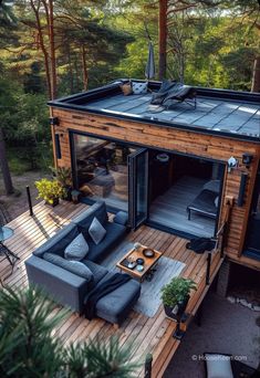 an aerial view of a living room and deck in the woods