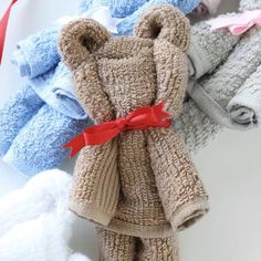 several knitted teddy bears are lined up on a white surface and tied with red ribbon