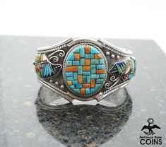 "Metal: Sterling .925 Silver Weight: 64.9 grams Measurements: 5.75\" inside circ. 1.25\" Gap 1.75\" Wide *This exquisite piece boasts amazing craftsmanship with Turquoise & Red Coral fashioned in the look of a basketweave at the center and Bears with a multi-stone inlay around its sides. Colorful and lavishly designed, this is one bracelet you will want to add your everyday wardrobe, so add this to your cart today! *P L E A S E * S E E * P H O T O S !" Southwestern Style Jewelry Bracelet With Inlay, Southwestern Style Bracelet With Inlay, Southwestern Inlay Bracelet, Southwestern Inlay Cuff Bracelet Gift, Artisan Multicolor Cuff Bracelet With Inlay, Artisan Multicolor Inlay Cuff Bracelet, Southwestern Turquoise Cuff Bracelet With Inlay, Southwestern Style Turquoise Cuff Bracelet With Inlay, Chinese Bracelet