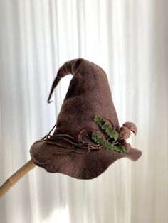 This hat is made of only one piece. To have this unique piece means to have all the magic :) Crafted from felted wool in shades of brown and mink, this enchanting witch hat is adorned with mushrooms, whimsical herbs, and dried branches, meticulously crafted using the wet felting technique. Reflecting the mysterious texture of nature, it adds an unforgettable touch to both Halloween parties and spirited theater performances. This hat will captivate everyone's attention and add a touch of mystique to your soul. All parts are hand-felted from soft merino wool by wet felt method. Mushrooms, whimsical herbs and dry branches on the hat are attached by felt needling or sewing methods. It is made of natural fibers, is nature-friendly and is completely nature-themed.  At Halloween, theater performa Handmade Witchy Costume Hats And Headpieces, Handmade Witchy Hat With Curved Brim, Brown Halloween Costume Hat, Felt Needling, Forest Wizard, Woodland Witch, Sewing Methods, Hat Halloween Costume, Brown Forest