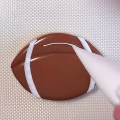 someone is painting a chocolate football on the wall