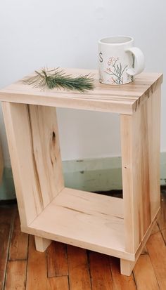 a small wooden table with a mug on top