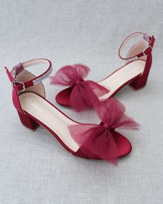 a pair of red high heeled shoes with bows