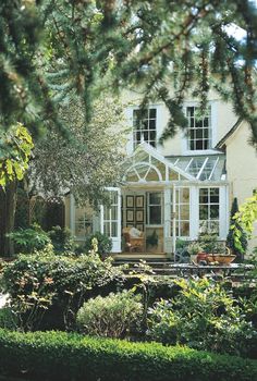 a white house surrounded by trees and bushes