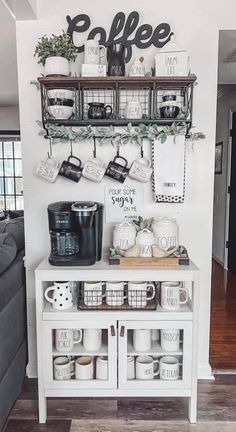 a coffee bar with cups and mugs on the shelves above it, along with other kitchen items