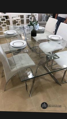 a glass table with white chairs around it