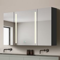 a bathroom vanity with two mirrors and lights