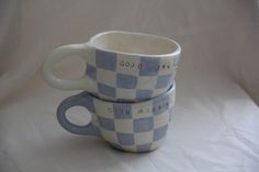 two blue and white checkered cups stacked on top of each other