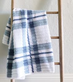 a blue and white blanket sitting on top of a wooden chair