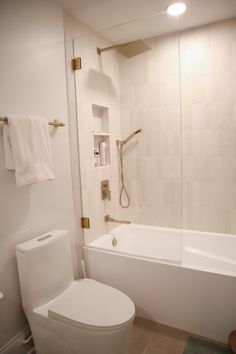 a white toilet sitting next to a bath tub