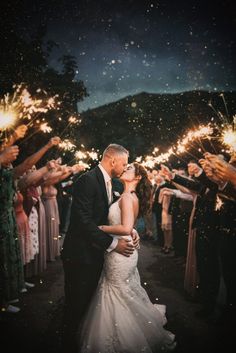 a bride and groom are surrounded by sparklers