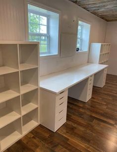 an empty room with white shelving and wooden floors