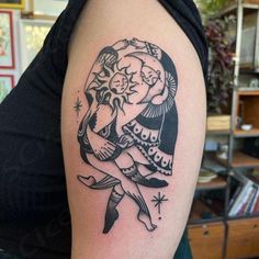 a woman's arm with a black and white tattoo design on her left shoulder