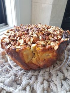 a cake sitting on top of a glass plate covered in nuts and other toppings