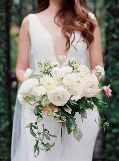 a bride holding a bouquet of white flowers