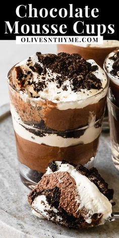 chocolate mousse cups with whipped cream and oreo cookies on the top one is half eaten