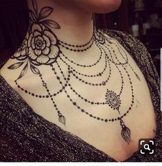 a woman's chest is adorned with black beads and flowers