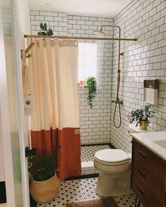 a white toilet sitting next to a bathroom sink under a shower curtain in a bathroom