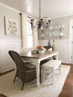 a dining room table with two chairs and a chandelier hanging from the ceiling