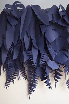 blue paper leaves are hanging on the wall