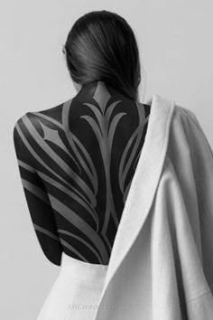 the back of a woman's body covered in black and white art work,