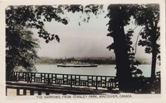 an old photo of a boat in the water near a dock with trees on both sides