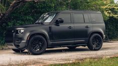 a black truck parked on top of a dirt road