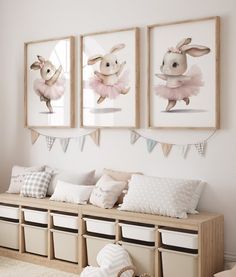 three framed pictures hang on the wall above a bench with storage bins underneath it