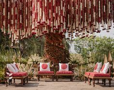 red and white pillows are hanging from the ceiling in front of some chairs with cushions on them