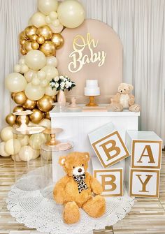 a teddy bear sitting on top of a table next to some balloons and other decorations