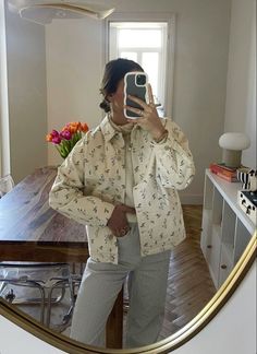 a woman taking a selfie in front of a mirror with her cell phone and wearing pajamas