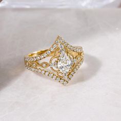 a gold ring with two rows of diamonds on it and a white bag in the background