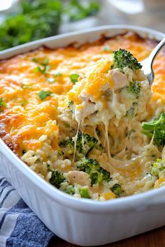 a casserole dish with broccoli and cheese being lifted by a fork