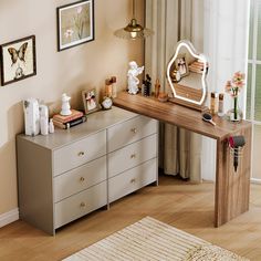 a desk with several items on it in front of a window and pictures hanging on the wall