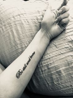 a woman's arm with a tattoo saying be still and know