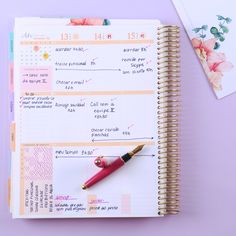 a planner with a pen on top of it next to a notepad and notebook