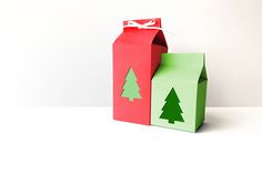 an origami box with christmas trees on it and a present in the front