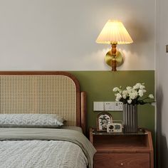 a bed sitting next to a nightstand with a lamp on top of it