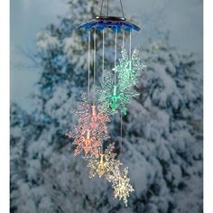 a wind chime with snowflakes hanging from it's sides in front of a tree