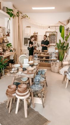 two people standing in a room filled with pottery