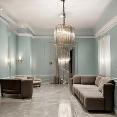 a living room with couches and a chandelier