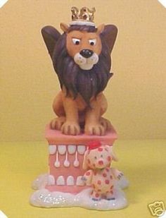 a lion figurine sitting on top of a toy castle with a dog next to it