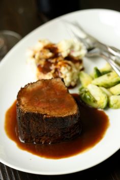 a white plate topped with meat and gravy