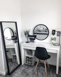 a white desk with two mirrors and a black chair