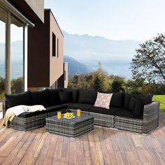 a black couch sitting on top of a wooden floor next to a table with orange juice