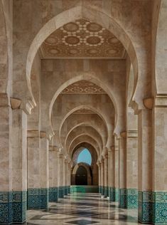 an ornate hallway with blue and white tiles on the walls, arches and flooring