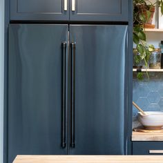 a large blue refrigerator freezer sitting next to a wooden counter top in a kitchen