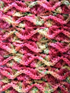 a crocheted blanket is shown in pinks and browns, as if it were made from yarn